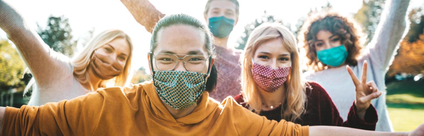 happy friends handing out outside with masks