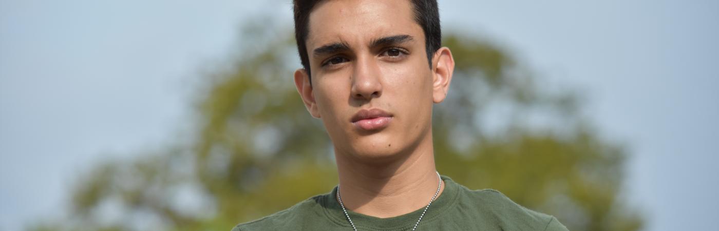 teen boy holding notebook