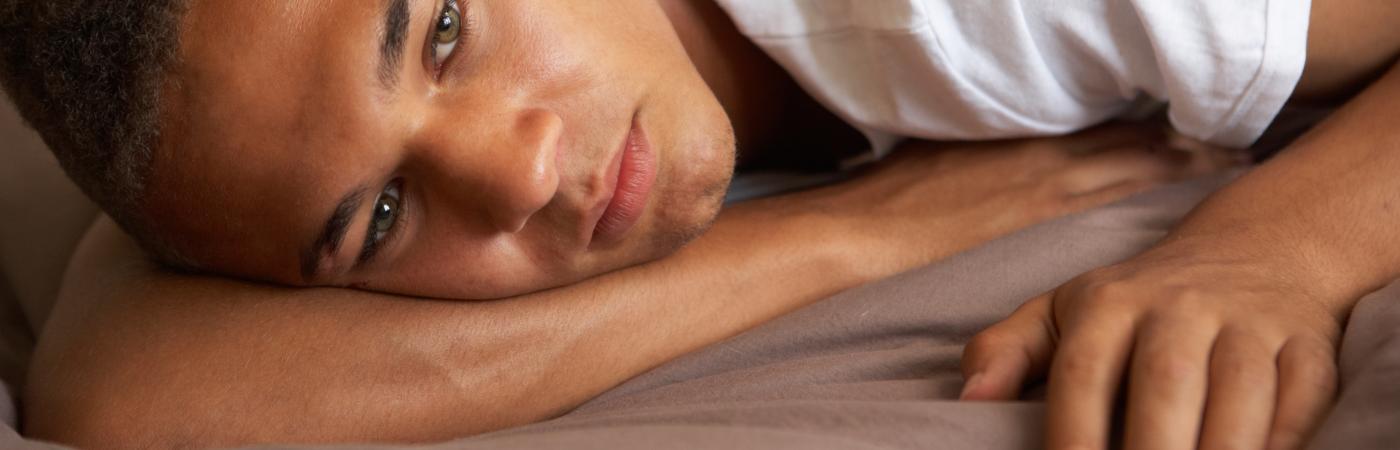 teen laying down with pills