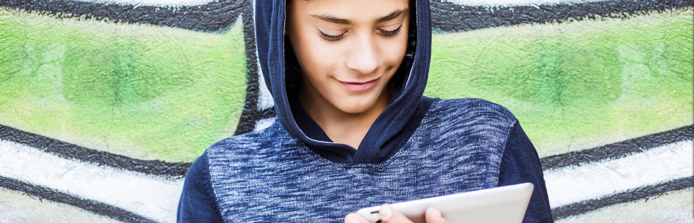 teen looking down at tablet