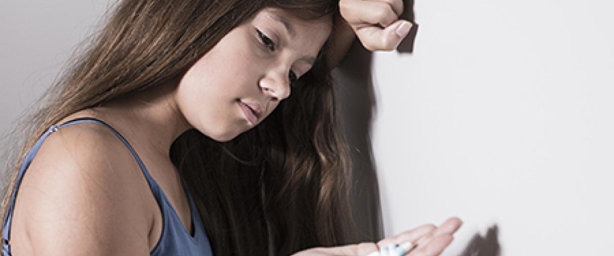 teen girl holding pills