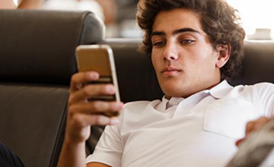 teen boy holding cell phone