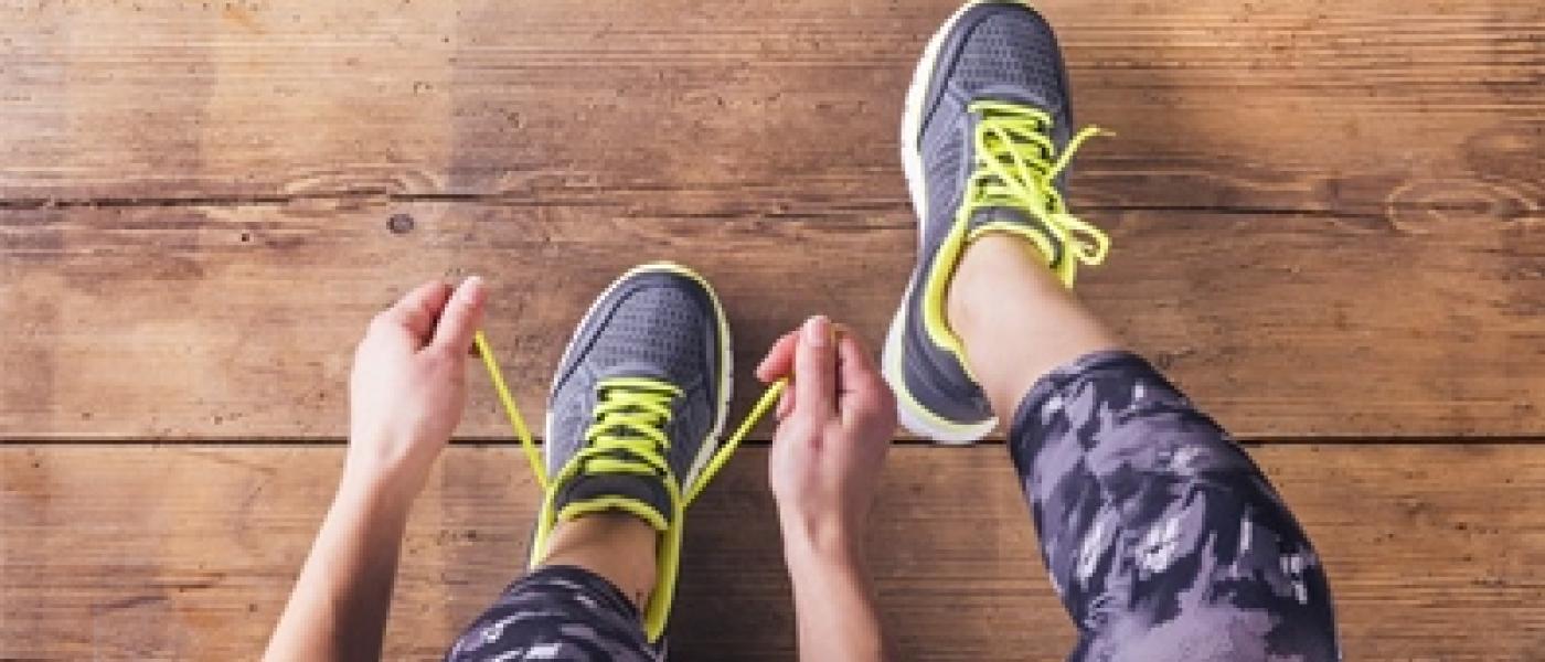 teen girl tying shoes, preparing to go for a jog