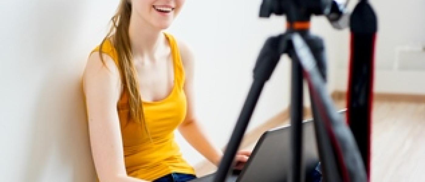 teen girl vlogging with laptop and video camera