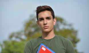 teen boy holding notebook