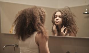 teen girl looking into mirror