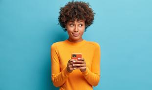 teen holding phone looking pensive